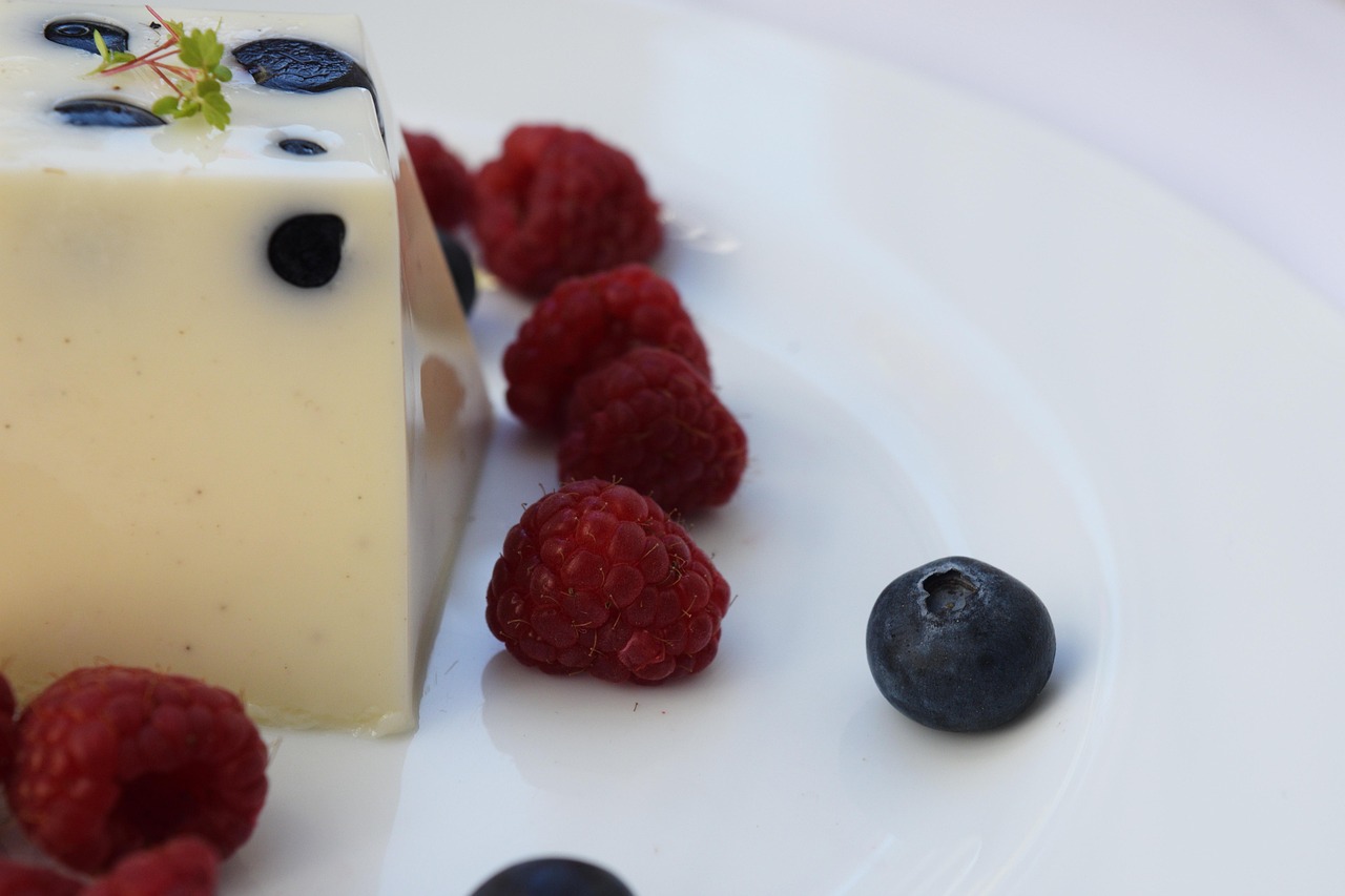 Panna cotta perfetta con consistenza tremolante, guarnita con frutti di bosco freschi.