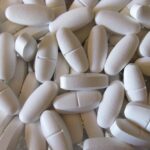 Integratore di magnesio con orologio, evidenziando il momento migliore per assumerlo.