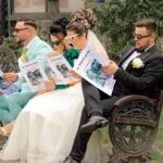 Due concorrenti sorridenti durante il gioco "Affari Tuoi" davanti a una valigia aperta.