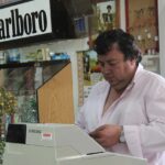 Immagine di un tabaccaio con biglietti Gratta e Vinci e un cliente sorridente che acquista.