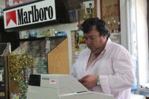 Immagine di un tabaccaio con biglietti Gratta e Vinci e un cliente sorridente che acquista.