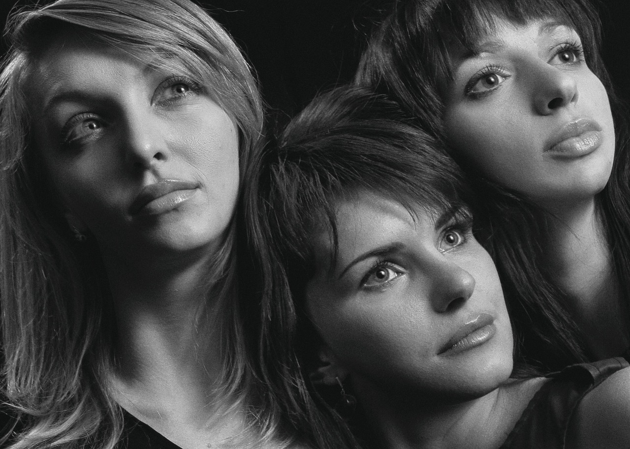 Giocatori sorridenti durante una puntata di Affari Tuoi, con valigette e presentatore sullo sfondo.