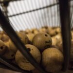 Giocatore felice celebra la vincita del 6 al Superenalotto con biglietto vincente in mano.